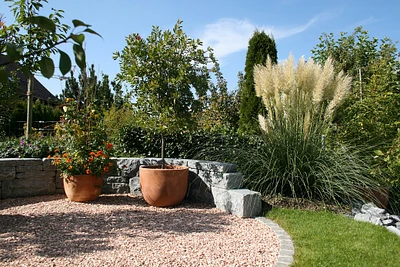 Eine Sitzmauer aus Natursteinen verleiht jedem Garten Charakter und Schönheit. Gräff AG - Ihr Gärtner, Gartenbau, Gartenpflege und Gartengestaltung