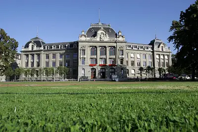 Gesamtansicht Hauptgebäude mit Rasenfläche im Vordergrund im Sommer. © Universität Bern
